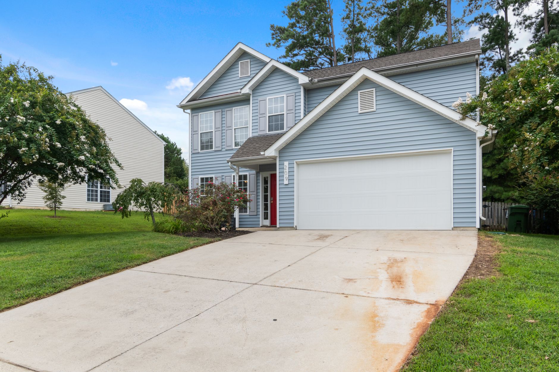 A suburban house with a double garage door and driveway.